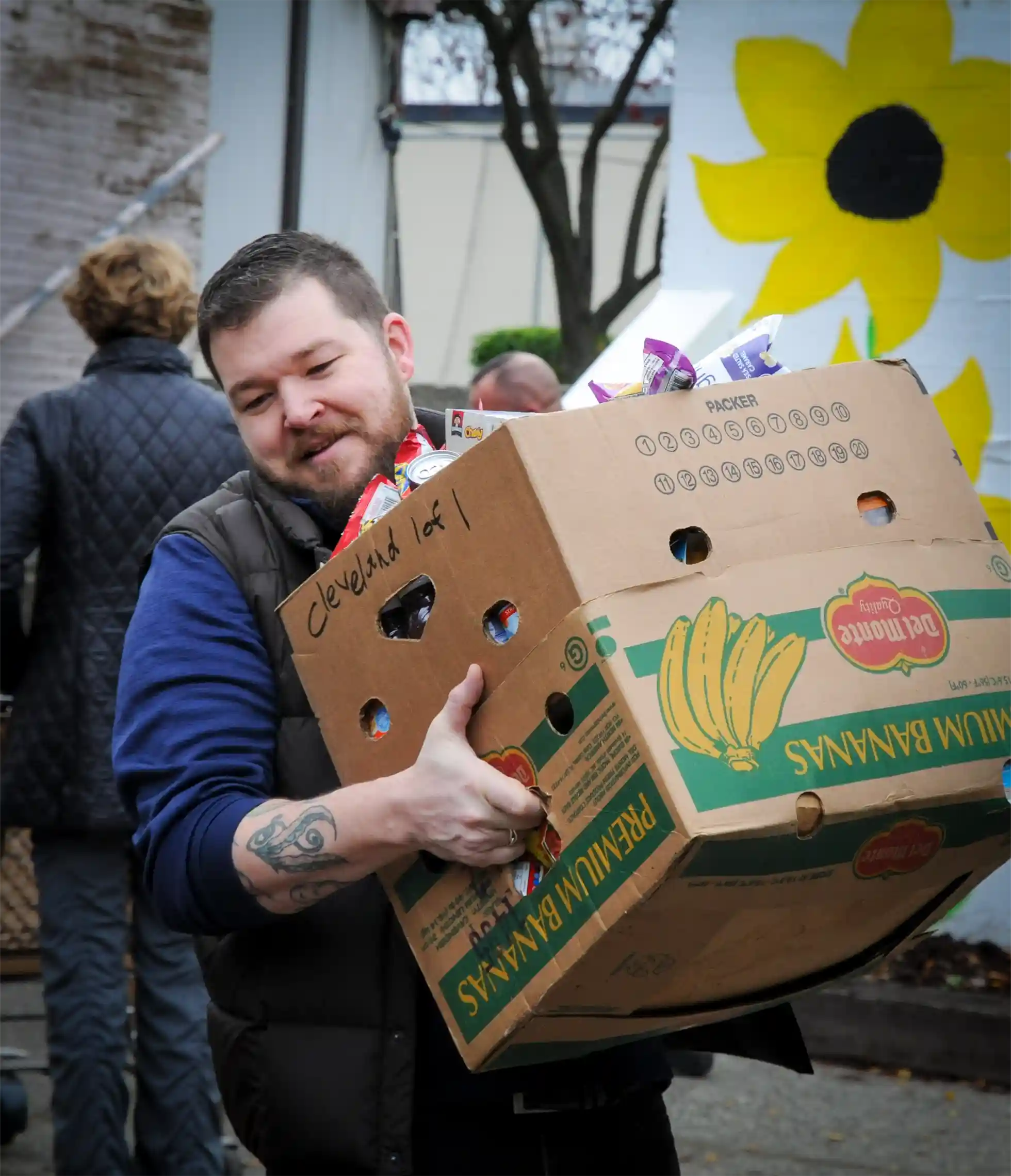 A volunteer carrying a box of food